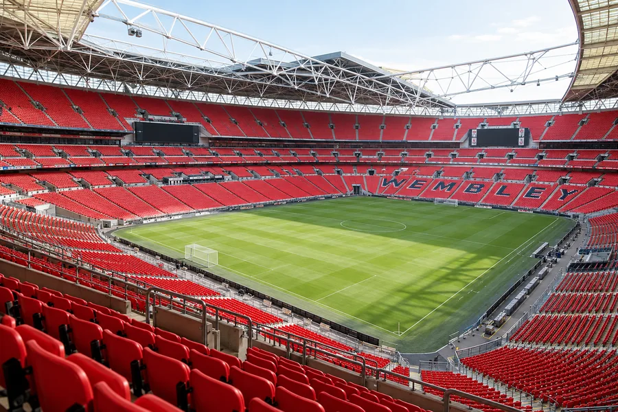 Wembley Stadium pitch and red seating viewed from the upper stands